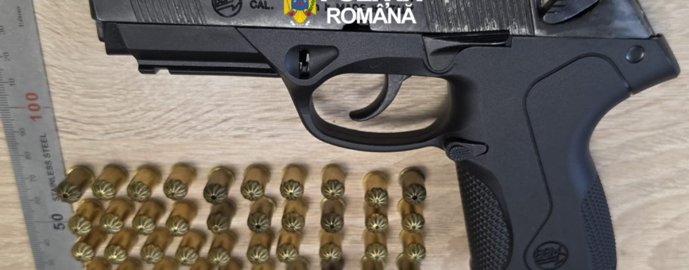 Black semi-automatic pistol with Romanian Police branding, placed on a wooden surface, with multiple brass cartridges arranged in rows below and a metal ruler for scale.