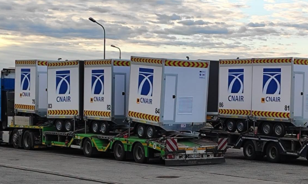 Row of CN AIR cargo containers on a multi-axle transport trailer at an airport tarmac.