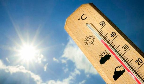 Wooden thermometer with a Celsius scale showing about 40°C, set against a bright blue sky with a shining sun.