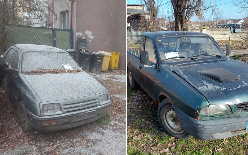 Two abandoned, dusty cars parked outdoors side by side; left is a gray sedan with a leaf-filled windshield, right is a blue pickup with rust and a dented bumper.