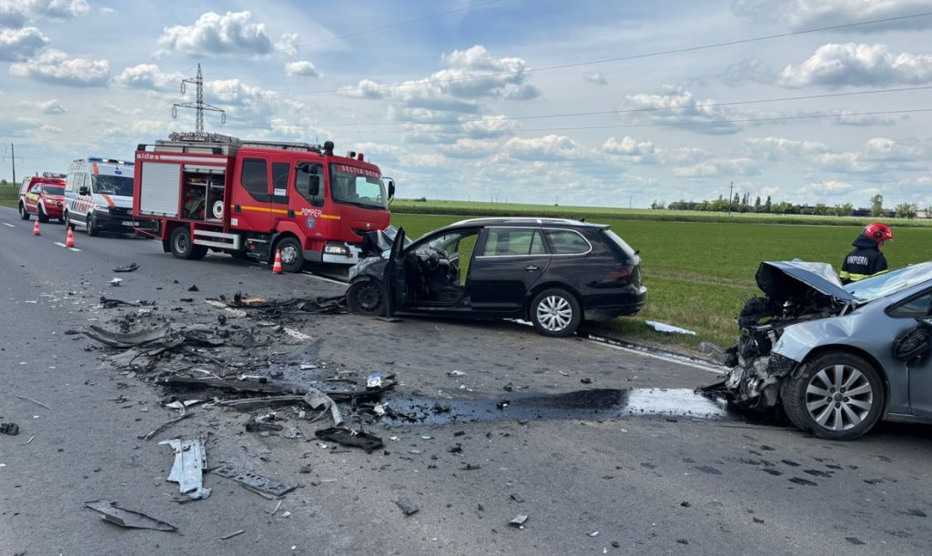 accident - Sursa de Vest Emergency responders and a red fire truck at a multi-vehicle crash on a rural highway, with debris scattered across the road.