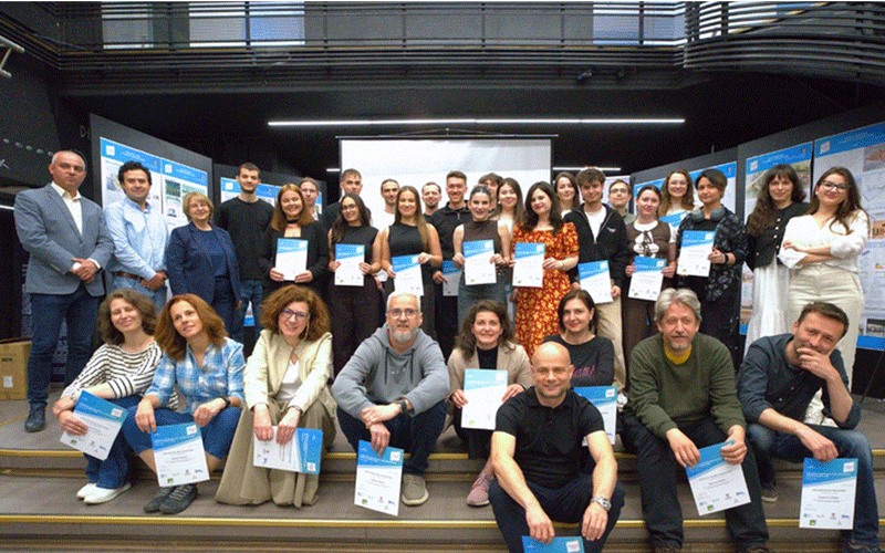 upt-competitie-arhitectura2 - Sursa de Vest Group of about 30 people on a stage posing with certificates at a conference awards ceremony."