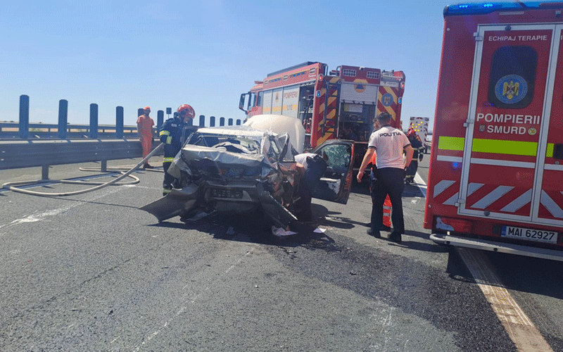 accident-a1 - Sursa de Vest Severely damaged car on a highway with responders and two ambulances at the scene of a crash, hoses on the road nearby.