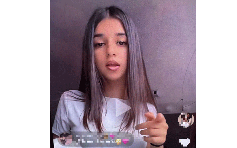 Young woman with long straight hair speaks to the camera in a livestream, with chat messages visible along the bottom.
