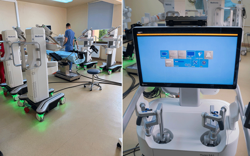 Operating room with patient on an operating table and multiple anesthesia machines on wheeled pedestals nearby, clinical staff in the background.