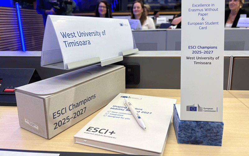 uvt - Sursa de Vest Signage for West University of Timisoara and ESCI Champions 2025–2027 on a reception desk at a conference, with a pen and a booklet labeled ESCIt+ on the table.