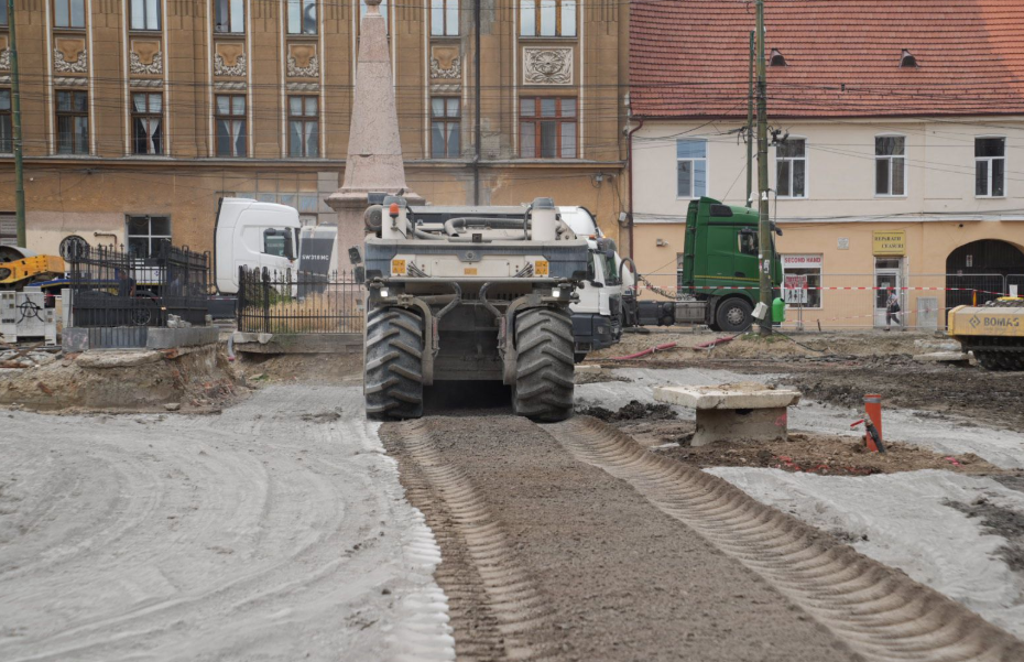 cartier fabric2 - Sursa de Vest Construction site on a city street with a large soil compactor driving on a dirt road in front of historic buildings