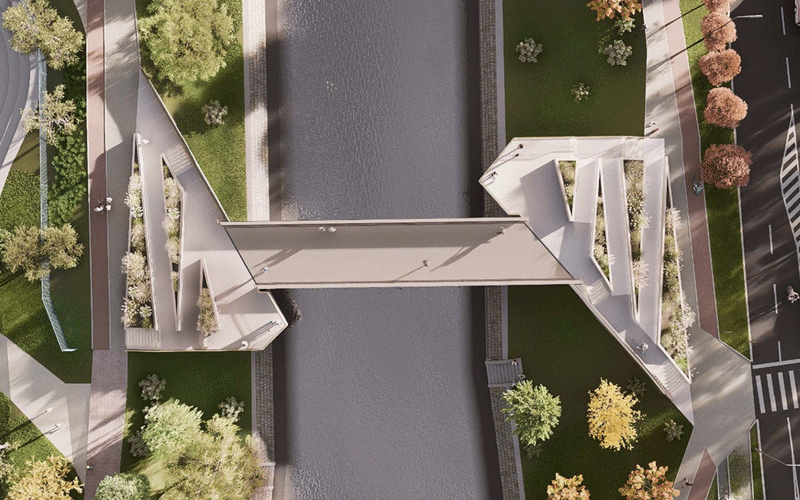 pasarela-indragostitilor3 - Sursa de Vest Aerial view of a modern zigzag pedestrian bridge spanning a narrow canal with green landscaped banks and surrounding roads on both sides.