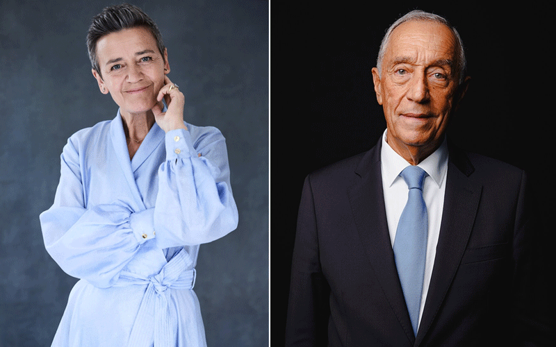 Two people shown side by side: a woman in a light blue bathrobe on the left and an older man in a dark suit with a light blue tie on the right.