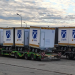 Row of CN AIR cargo containers on a multi-axle transport trailer at an airport tarmac.