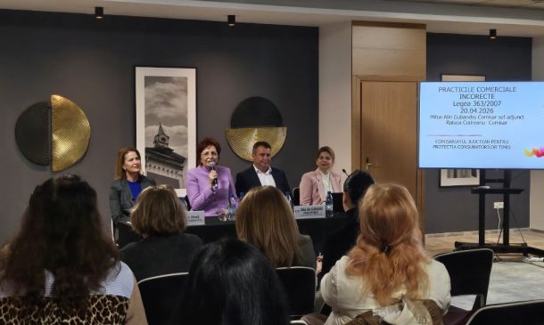 Panel discussion with four speakers seated at a long table, audience watching, and a slide projected on the right in Romanian.