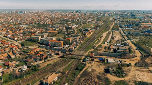 Aerial view of a town with multiple rail lines crossing a central area, bordered by residential blocks and roads.