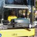 Public transit bus front view with a driver in a yellow shirt; Timisoara branding and accessibility icons on the bumper.