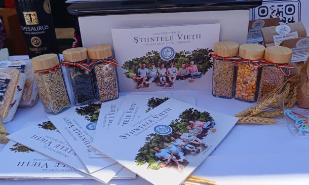 Table display of grain packets and glass jars with ribbons, plus brochures and a university poster in the background.