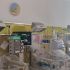 NICU room with several infant incubators and medical monitors mounted on a yellow wall panel.