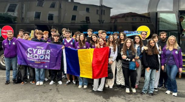 Group of students posing in front of a bus, holding a purple 'Cyber Moon' banner and a Romanian flag.