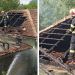 Firefighter in helmet and turnout gear on a heavily damaged tiled roof, directing a water spray as smoke rises from the burned house.