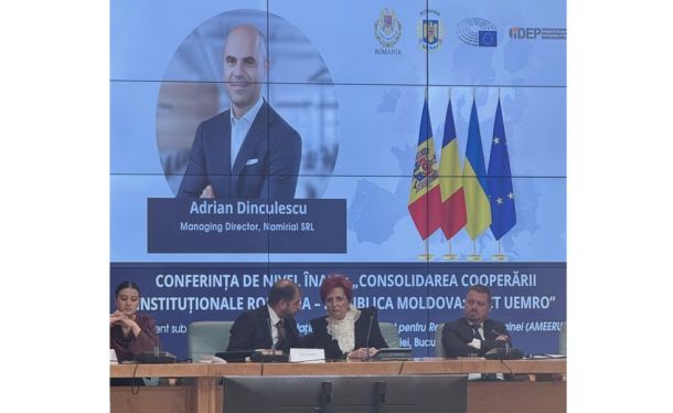 Panel of four seated at a conference table; a large screen behind features a man’s portrait and flags of Romania, Moldova, and the EU.
