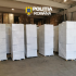 Stacks of white-wrapped pallets in a spacious warehouse with the Poliția Română logo overhead