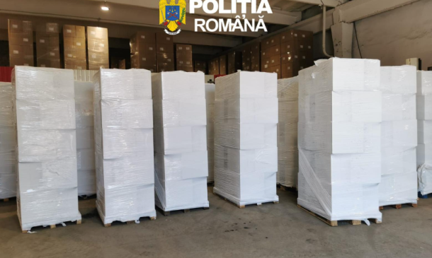 Stacks of white-wrapped pallets in a spacious warehouse with the Poliția Română logo overhead